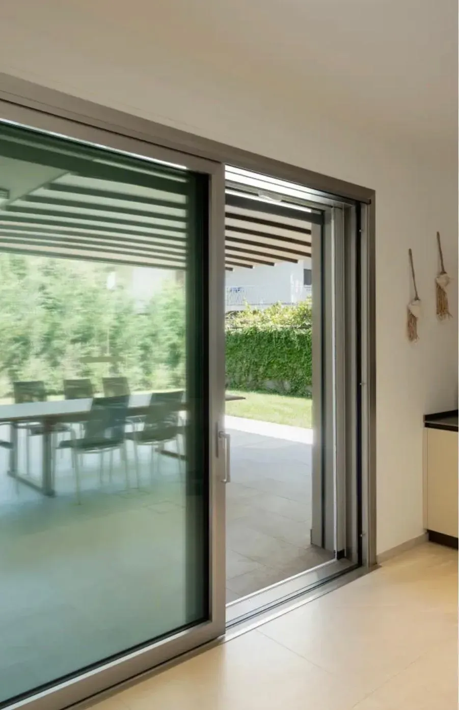 Immagine illustrativa di porta finestra alzante scorrevole con telaio in alluminio e vetrata ampia in ambiente residenziale moderno