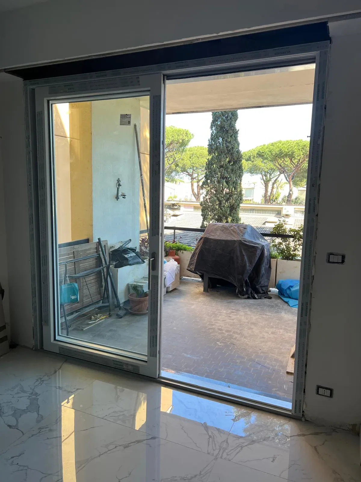 Immagine illustrativa di finestra traslante vasistas aperta in posizione di ventilazione con infisso in PVC bianco