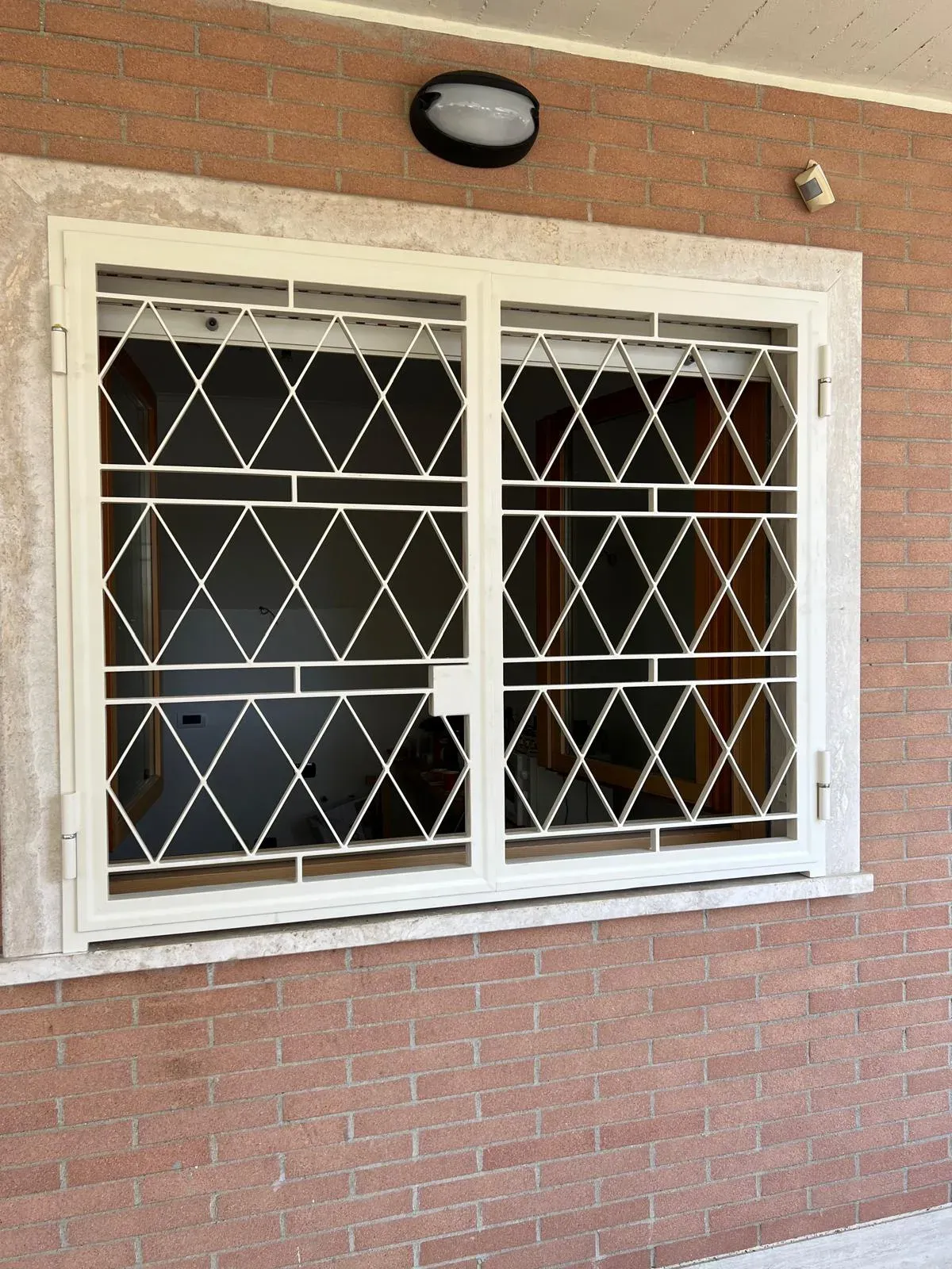 Inferriata apribile a battente su finestra doppia con apertura esterna