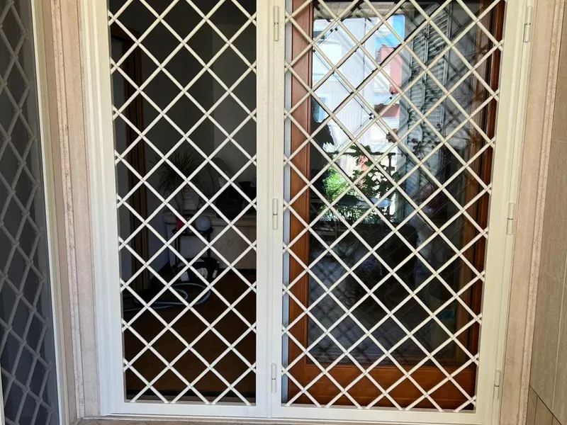Inferriate in ferro bianco installate su portafinestra per sicurezza abitativa ad Aprilia, Roma e provincia