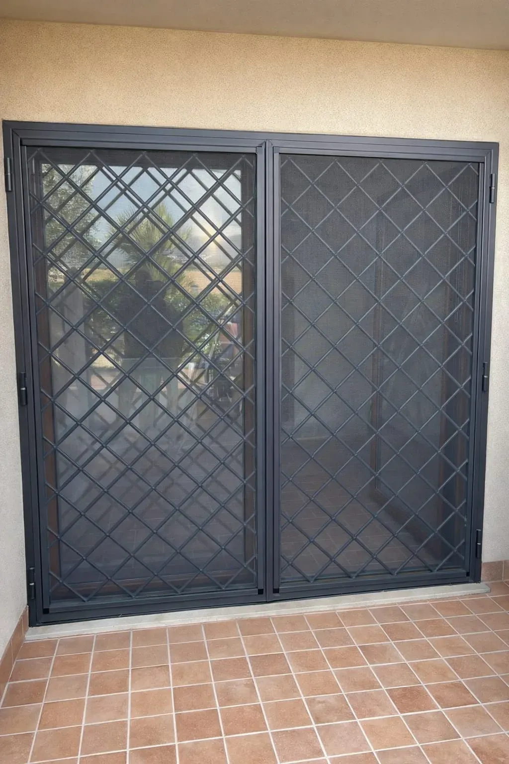 Zanzariera su misura a battente con telaio antracite installata su portafinestra per protezione insetti e ventilazione naturale